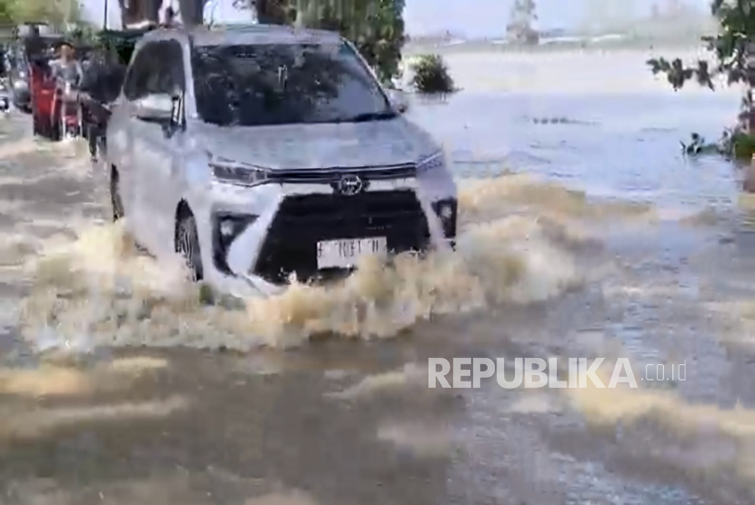 Banjir mneggenangi jalan provinsi penghubung Cirebon-Indramayu, di Desa Bayalangu Kidul, Kecamatan Gegesik, Kabupaten Cirebon, Selasa (25/2/2025). 