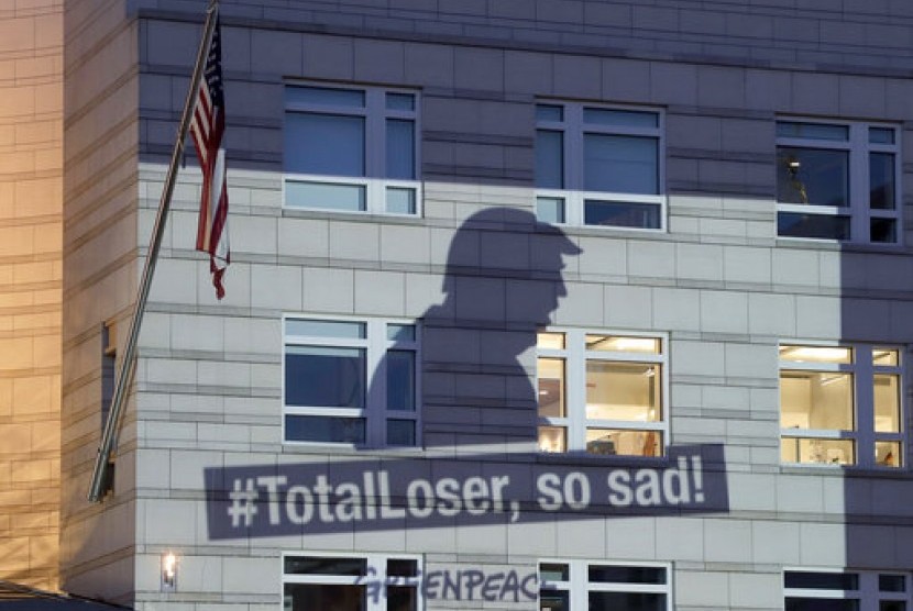 Banner Greenpeace menunjukkan Presiden AS Donald Trump dan slogan #TotalLoser, so sad! (#Pecundang, sangat menyedihkan!) yang diproyeksikan di gedung Kedubes AS, Jerman, Jumat (2/6).