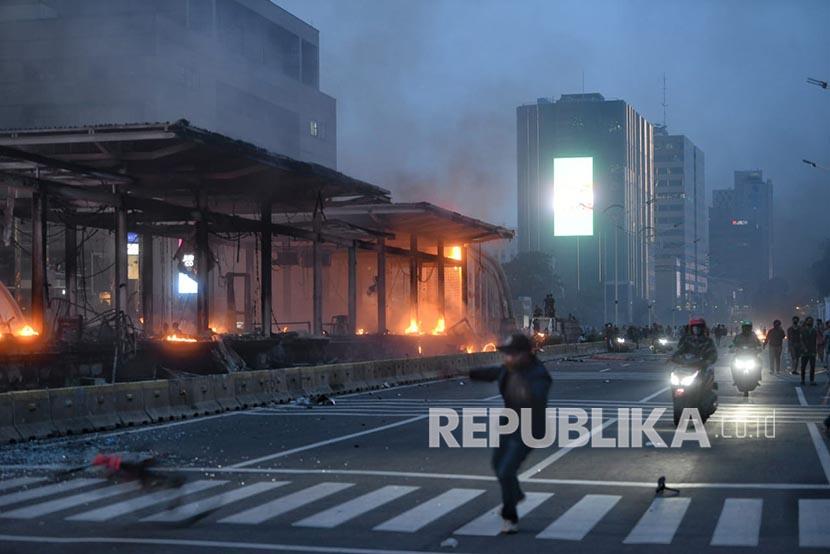 Bara api dan asap mengepul dari sisa bangunan halte Transjakarta di Bundaran HI, Jakarta, Kamis (8/10). Halte yang menjadi akses ke stasiun MRT ini hangus dibakar massa yang dipukul mundur dari area bundaran Bank Indonesia.
