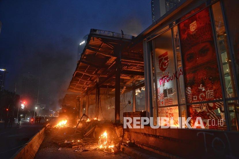 Bara api dan asap mengepul dari sisa bangunan halte Transjakarta di Bundaran HI, Jakarta, Kamis (8/10). Halte yang menjadi akses ke stasiun MRT ini hangus dibakar massa yang dipukul mundur dari area bundaran Bank Indonesia.