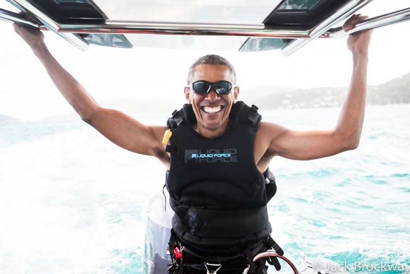 Barack Obama tersenyum saat menikmati liburan bersama Richard Branson.