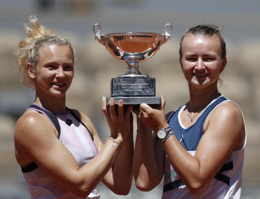 Barbora Krejcikova (kanan) dan Katerina Siniakova mengangkat trofi juara ganda putri French Open 2021.