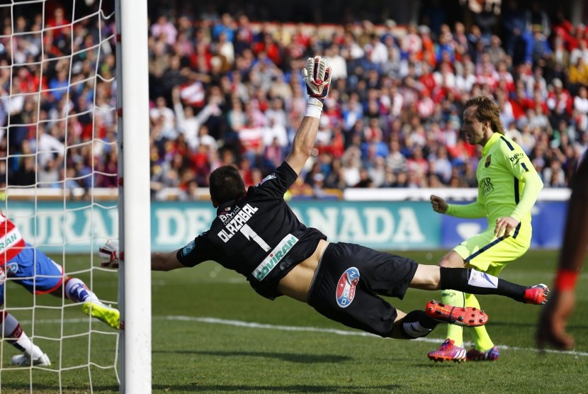 Barcelona's Ivan Rakitic (R) scores a goal past Granada's goalkeeper Oier Olazabal during their Spanish first division soccer match at Nuevo Los Carmenes stadium in Granada February 28, 2015