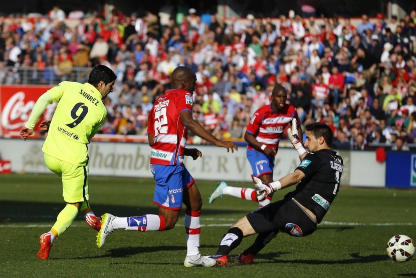 Barcelona's Luis Suarez (L) scores past Granada's goalkeeper Oier Olazabal during their Spanish first division soccer match at Nuevo Los Carmenes stadium in Granada February 28, 2015.