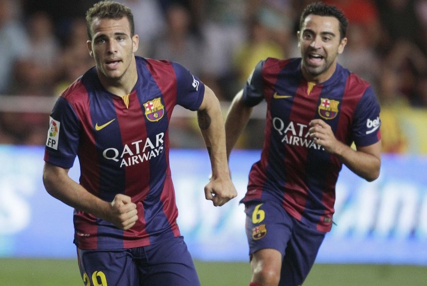 Barcelona's Sandro Ramirez (L) celebrates next to team mate Xavi Hernandez after he scored against Villarreal during their Spanish first division soccer match at the Madrigal stadium in Villarreal August 31, 2014. 