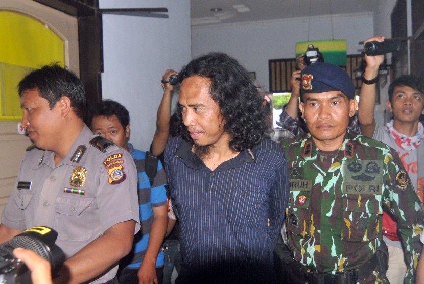 Basri alias Bagong (tengah) salah satu anggota kelompok bersenjata Santoso Mujahidin Indonesia Timur (MIT) ketika digiring mememasuki ruangan pemeriksaan kesehatan di RS. Bhayangkara, Palu, Sulawesi Tengah, Rabu (14/9).