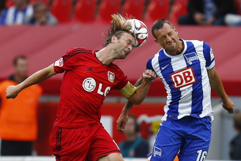 Bayer Leverkusen's Simon Rolfes (L) and Hertha BSC Berlin's Julian Schieber fight to head the ball during the German first division Bundesliga soccer match in Leverkusen August 30, 2014.