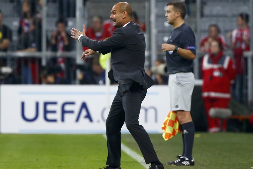 Bayern Munich's coach Josep Guardiola stands on the pitch as he shouts to his players during the Champions League group E soccer match against Manchester City, in Munich September 17, 2014