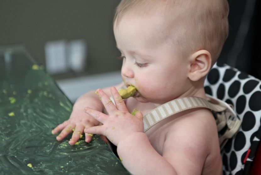 Seorang anak makan. Ada beberapa trik agar anak tidak melakukan gerakan tutup mulut saat makan.