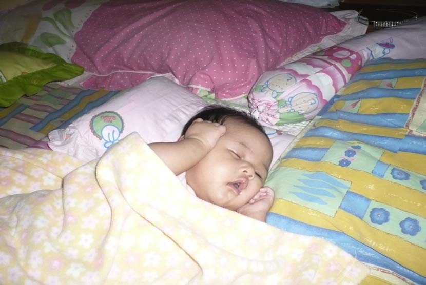 Bayi tidur di kasur (ilustrasi). Tidur di samping bayi dapat membahayakan nyawanya.