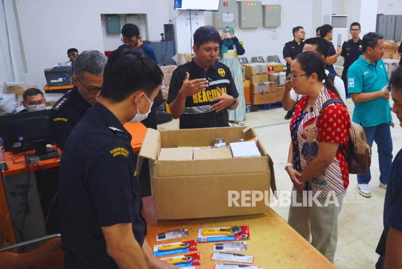 Bea Cukai memberikan penjelasan langsung kepada Miss Yuni, TKW di Hong Kong bahwa pemeriksaan setiap barang kiriman dilakukan secara prosedural.