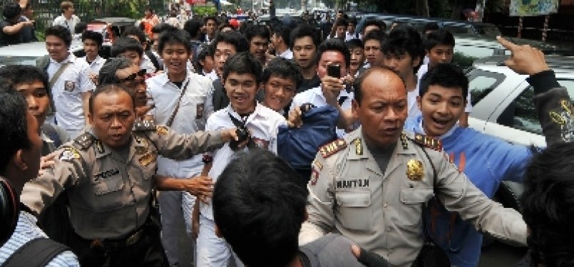 Beberapa anggota Kepolisian menahan sejumlah siswa SMAN 6 yang akan menyerang wartawan, Senin (19/9). 