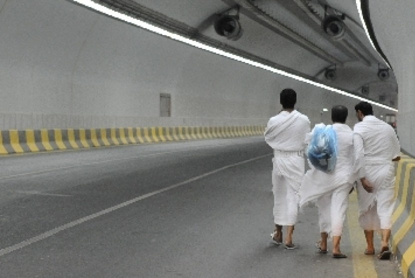 Beberapa jamaah haji menggunakan pakaian ihram berjalan melintasi terowongan King Fahd menuju Mina ketika akan melakukan tarwiyah, di Makkah, Arab Saudi.
