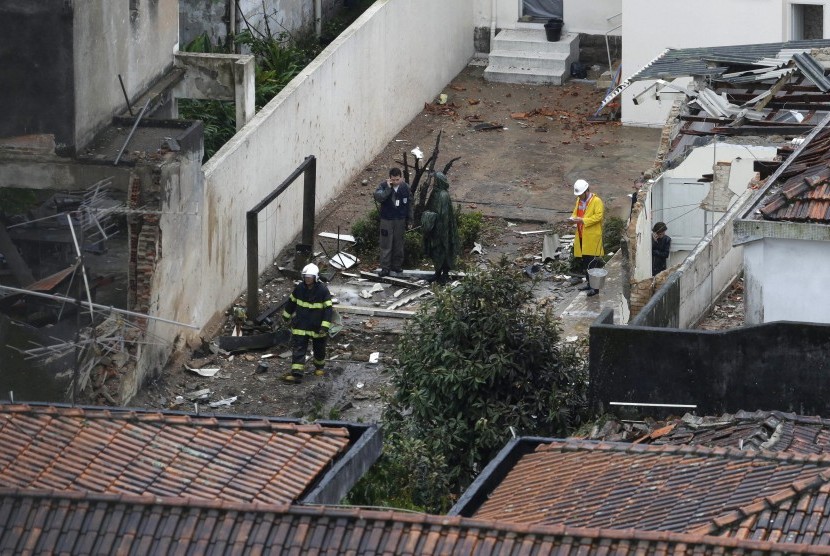 Beberapa orang sedang bekerja di lokasi jatuhnya pesawat kandidat presiden Brasil, Eduardo Campos di Santos, Rabu (13/8)