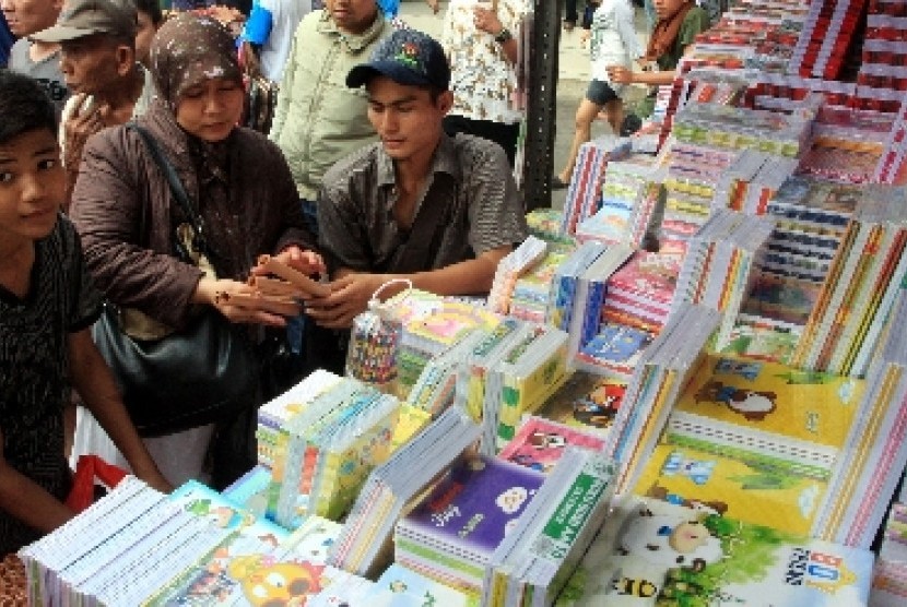 Beberapa orang tua mencari buku tulis untuk anaknya di Pasar Jatinegara, Jakarta, Jumat (13/7). 
