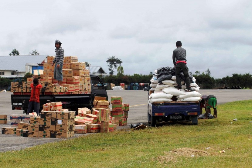 Beberapa pekerja sedang mengangkut sejumlah barang ke atas kendaraan usai didatangkan dari jayapura dengan menggunakan pesawat cargo di Bandara Wamena, Jumat (9/12).