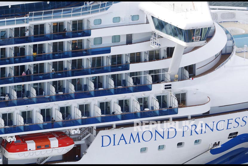 Beberapa penumpang kapal pesiar Diamond Princess tampak di jendela saat berlabuh di Pelabuhan Yokohama untuk mengisi perbekalan di Yokohama, Jepang, Kamis (6/2).  Hingga Kamis (13/2), kasus corona baru masih ditemukan dari penumpang kapal pesiar Diamond Princess.