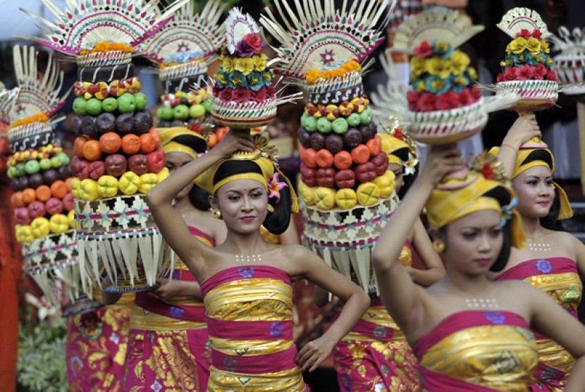Beberapa seniman membawa sesajen dalam Parade Pesta Kesenian Bali ke-34 di Denpasar, Bali,