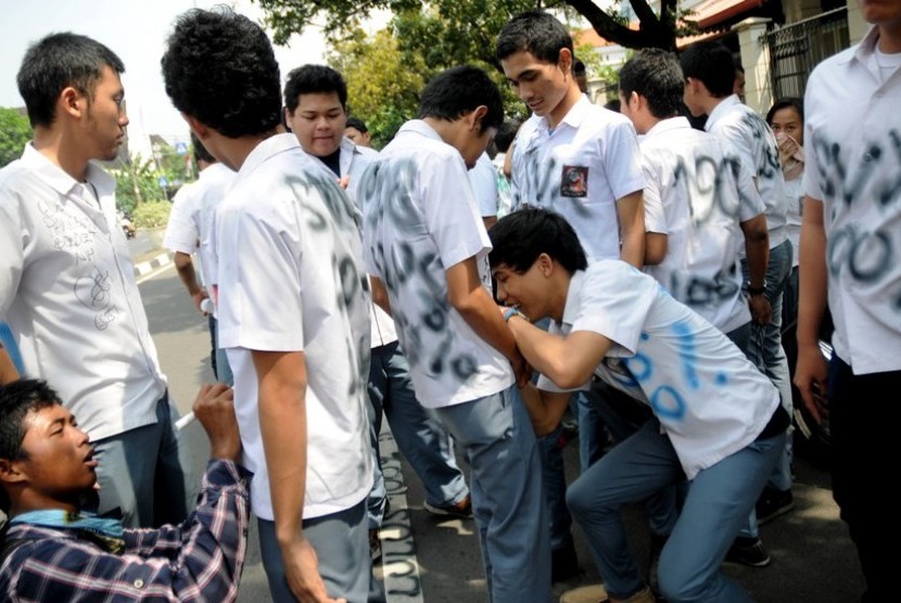  Beberapa siswa melakukan aksi corat-coret saat pengumuman kelulusan Ujian Nasional (UN) tingkat SMA/MA di SMA Negeri 1 Jakarta, Sabtu (26/5). (Prayogi/Republika)