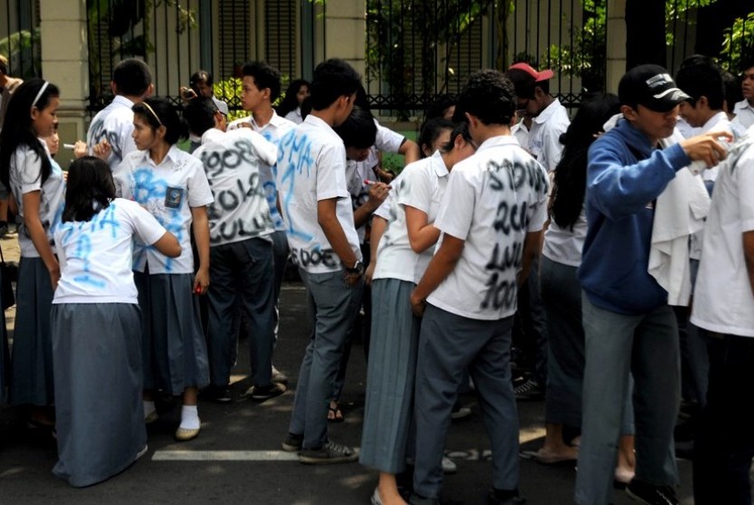  Beberapa siswa melakukan aksi corat-coret saat pengumuman kelulusan Ujian Nasional (UN) tingkat SMA/MA di SMA Negeri 1 Jakarta, Sabtu (26/5). (Prayogi/Republika)