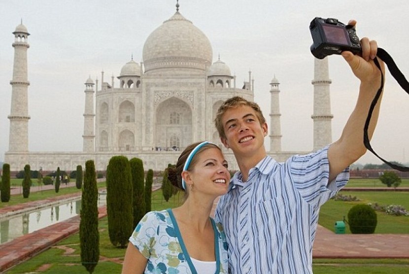 Beberapa turis menjadikan Taj Mahal sebagai spot foto yang menarik