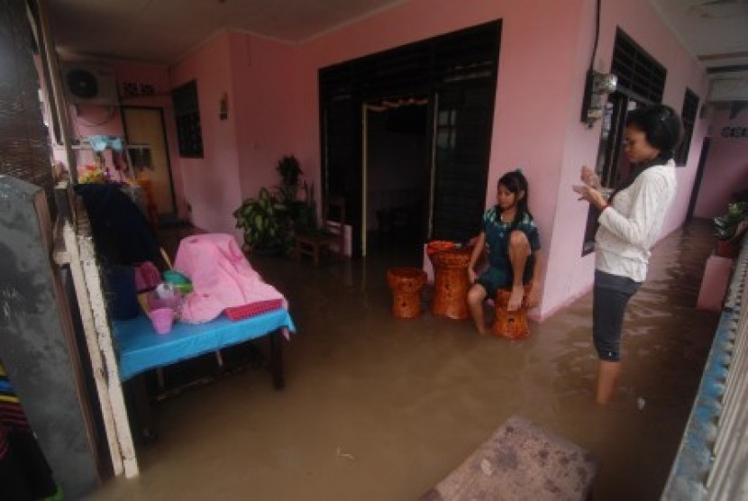 Beberapa warga berada dirumahnya yang dilanda banjir di kelurahan Mahakam Lingkungan IV, kecamatan Singkil, kota Manado, Sulawesi Utara, Minggu (17/2). Akibat diguyur hujan selama dua hari disejumlah lokasi rawan banjir di kota Manado digenangi air mencapa