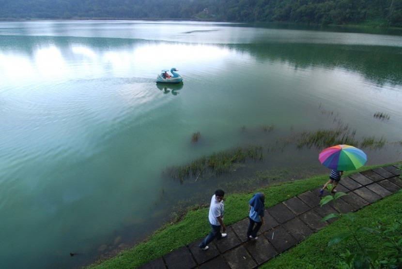 Beberapa wisatawan lokal berjalan dipinggir Danau Linow, kota Tomohon, Sulawesi Utara