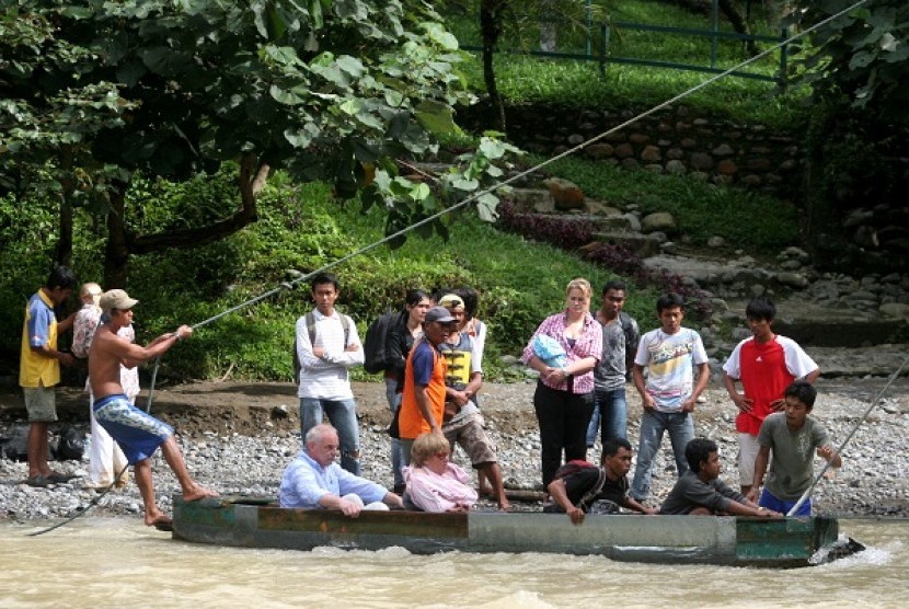 Beberapa wisatawan lokal maupun mancanegara menyeberang menggunakan perahu kayu (getek) di kawasan Objek Wisata Alam Bukit Lawang, Bahorok, Kab Langkat, Sumut, Kamis (17/5).