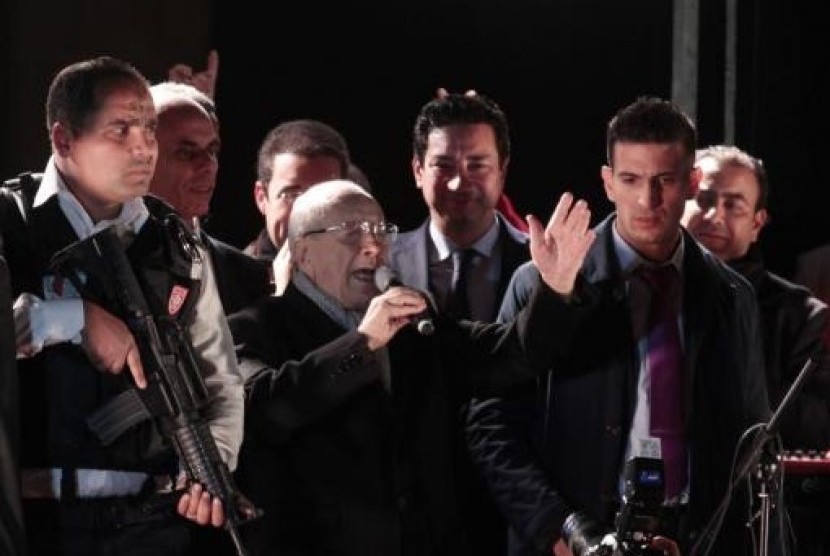 Beji Caid Essebsi (center), Nidaa Tounes party leader, gestures outside the party headquarters in Tunis December 21, 2014.