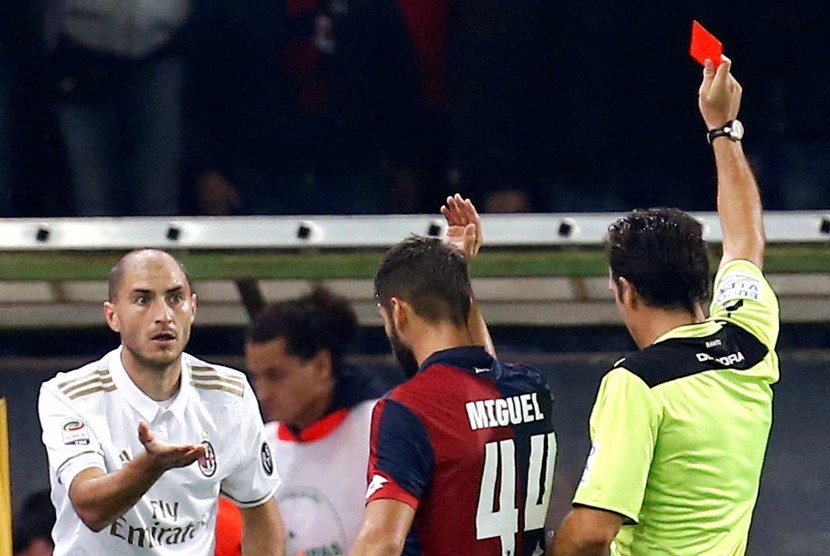 Bek AC Milan, Gabriel Paletta (kiri) menerima kartu merah dari wasit Luca Banti pada laga Serie A lawan Genoa, di stadion Luigi Ferraris, Rabu (26/10) dini hari WIB. Pada laga itu, Milan kalah 0-3.