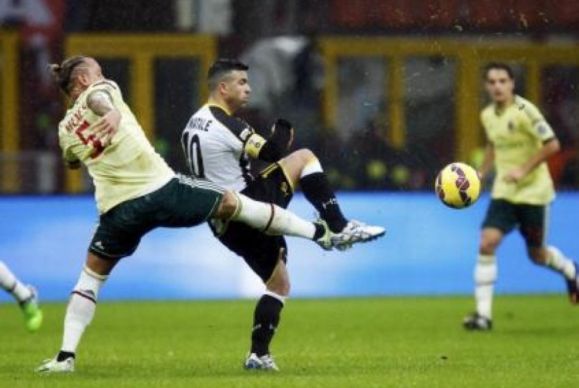 Bek AC Milan Philippe Mexes (kiri) mengganggu penyerang Udinese Antonio Di Natale dalam laga Serie A, Ahad (30/11).