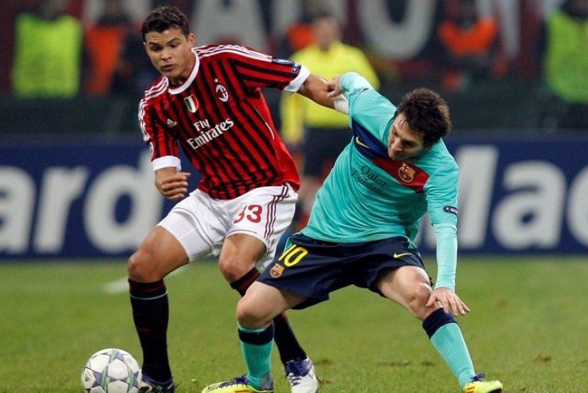 Bek AC Milan Thiago Silva berduel dengan penyerang Barcelona Lionel Messi