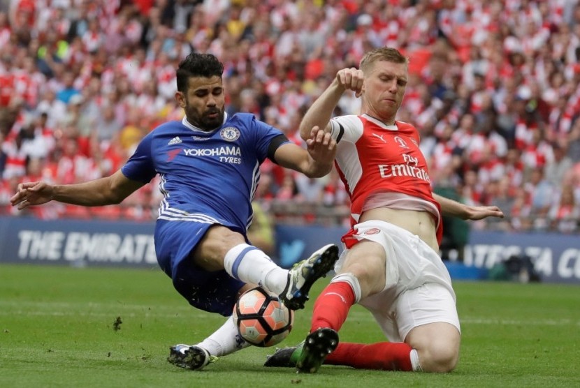 Bek Arsenal Per Mertesacker (kanan) saat menghentikan penyerang Chelsea Diego Costa.