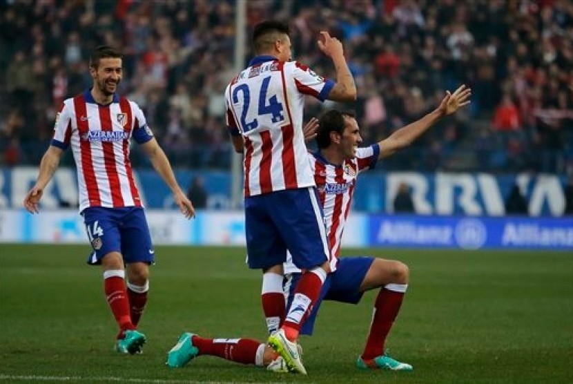 Bek Atletico Madrid Diego Godin (berlutut) merayakan golnya ke gawang Levante dalam lanjutan La Liga di Vicente Calderon, Sabtu (3/1).