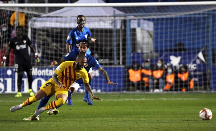 Bek Barcelona Dani Alves (bawah) terjatuh saat beraksi memperkuat timnya menghadapi Linares Deportivo di Copa del Rey.