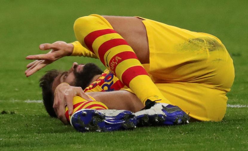 Bek Barcelona Gerard Pique mengerang kesakitan saat melawan Atletico Madrid.