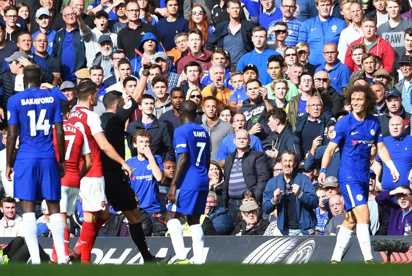 Bek Chelsea David Luiz (kanan) diusir keluar oleh wasit Michael Oliver setelah melakukan tekel keras kepada Sead Kolasinac pada pertandingan Liga Primer antara Chelsea dan Arsenal di Stamford Bridge, Ahad (17/9). 