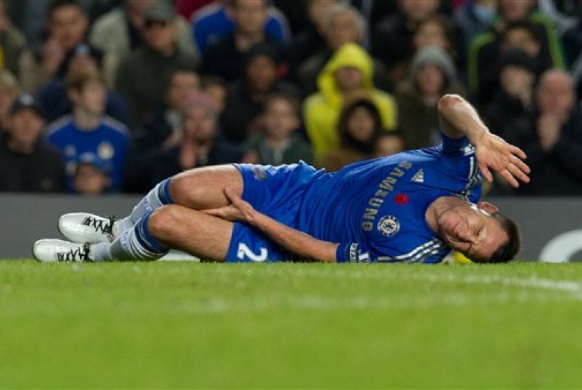 Bek Chelsea, John Terry, meringis kesakitan usai terkena tekel penyerang Liverpool, Luis Suarez, pada laga yang berlangsung di Stamford Bridge, Senin (12/11) dini hari.