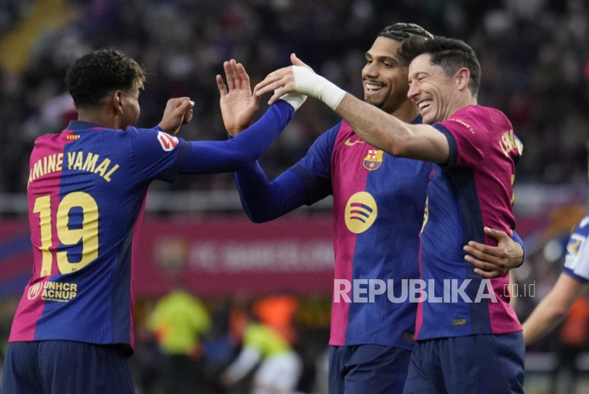 Bek FC Barcelona Ronald Araujo (tengah) merayakan gol bersama rekan setimnya Robert Lewandowski (kanan) dan Lamine Yamal dalam pertandingan La Liga Spanyol kontra Real Sociedad di Stadion Olimpiade Lluis Companys, Barcelona Ahad, 2 Maret 2025. 