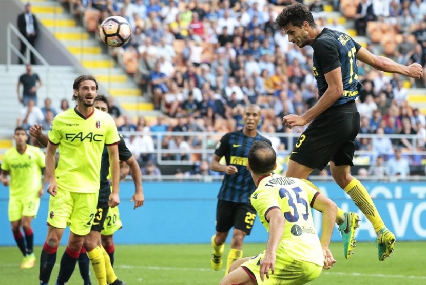 Bek Inter Milan Andrea Ranocchia (kanan) melepaskan tandukan ke gawang Bologna.