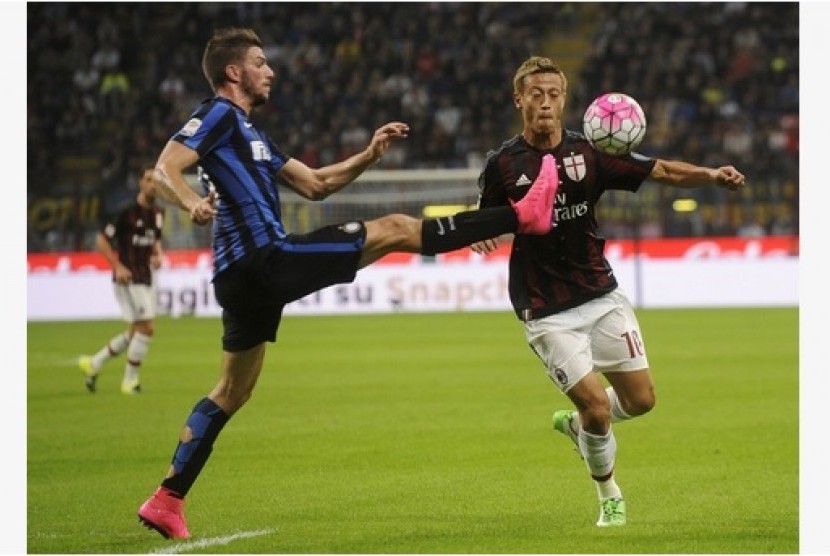 Bek Inter Milan Davide Santon (kiri) berebut bola dengan gelandang AC Milan Keisuke Honda.