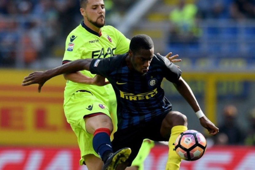Bek Inter Milan, Geoffrey Kondogbia berebut bola dengan striker Bologna, Matia Destro pada laga Seri A, Ahad (25/9). Kesalahan Kondogbia dinilai sebagai penyebab gol Destro.
