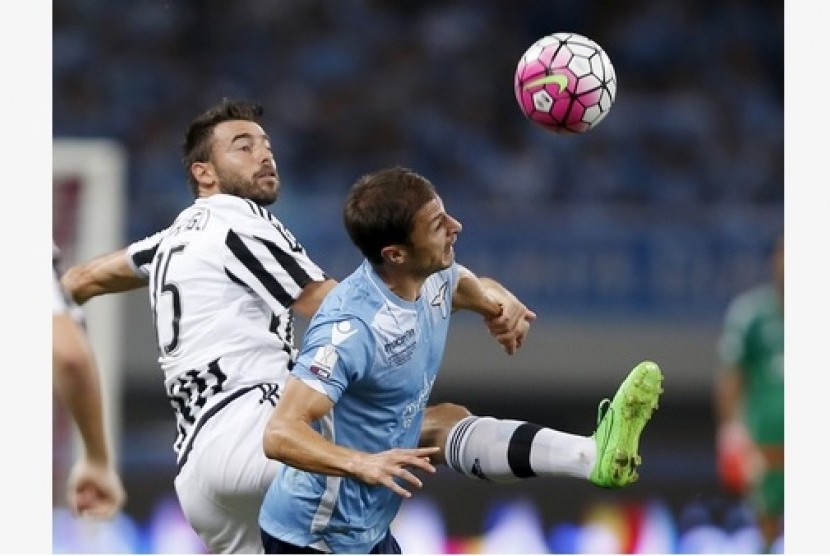 Bek Juventus Andrea Barzagli (kiri) berduel bola dengan gelandang Lazio Stefan Radu