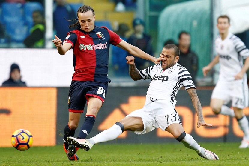 Bek Juventus, Dani Alves (kanan) saat mencoba mengganjal pemain Genoa, Diego Laxalt pada laga Serie A di stadion Luigi Ferraris, Ahad (27/11). Alves menderita patah tulang pascalaga.