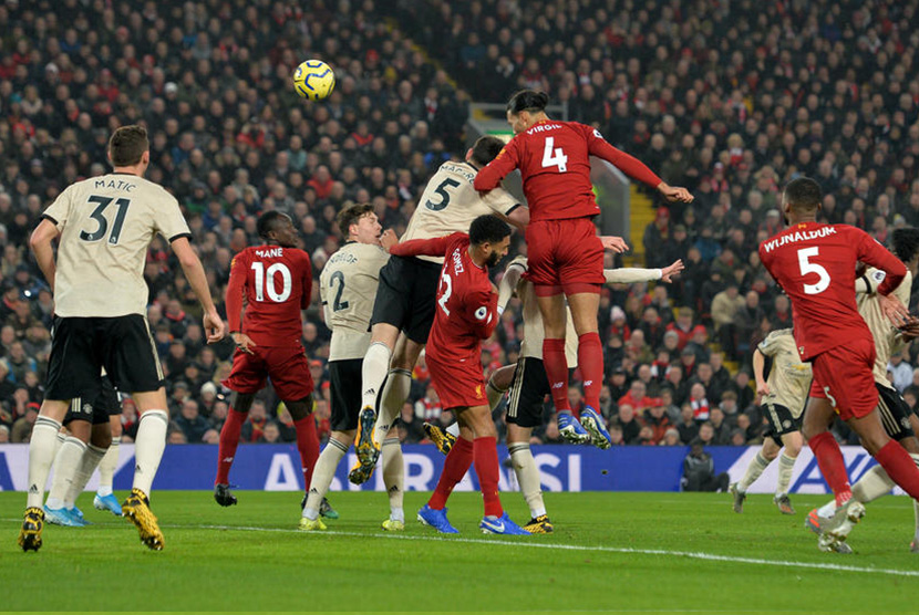 Bek Liverpool Virgil van Dijk (tengah) mencetak gol ke gawang Manchester United lewat sundulan pada laga lanjutan Liga Primer Inggris di Anfield, Liverpool, Ahad (19/1).