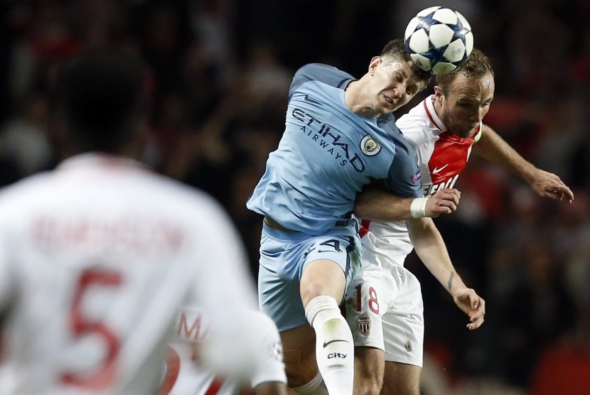 Bek Manchester City, John Stones berduel udara dengan striker AS Monaco, Valere Germain pada laga Liga Champions di Stade Louis II, Kamis (16/3) dini hari WIB. City akhirnya tersingkir.