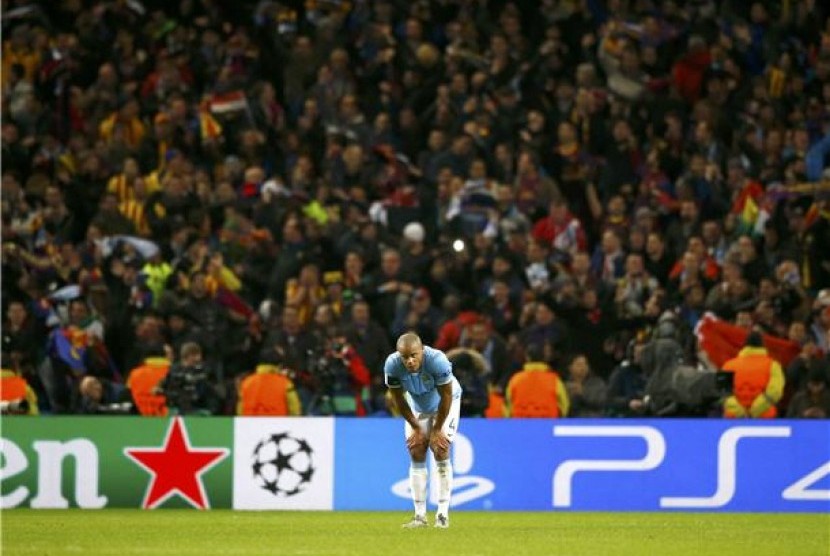 Bek Manchester City, Vincent Kompany, tertunduk lesu setelah Barcelona mencetak gol keduanya lewat Dani Alves dalam leg pertama babak 16 besar Liga Champions di Stadion Etihad, Manchester, Selasa (18/2). 