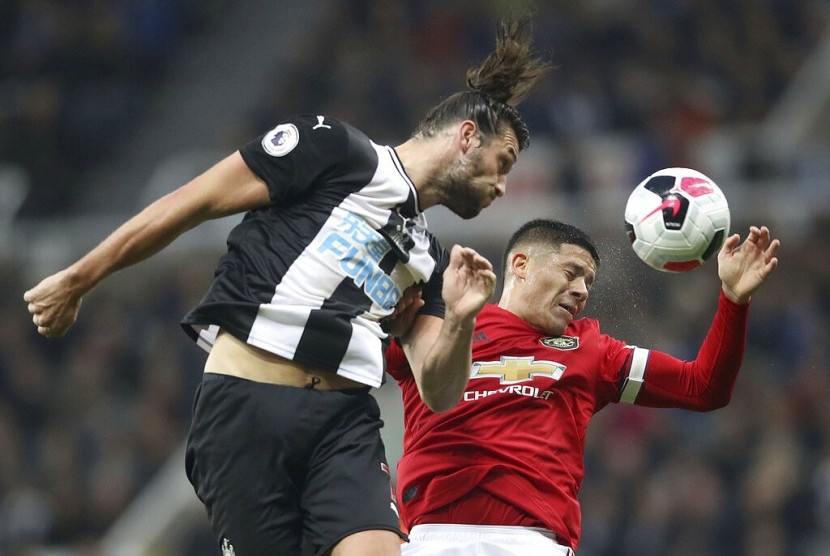 Bek Manchester United Marcos Rojo (kanan) menjaga penyerang Newcastle United Andy Carroll