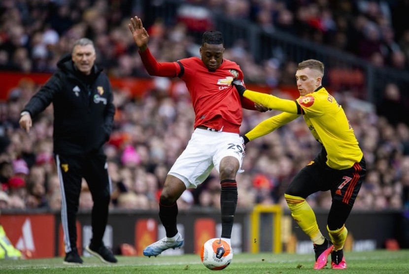 Bek Manchester United (MU) Aaron Wan-Bissaka (kiri) berebut bola dengan gelandang Watford Gerard Deulofeu.