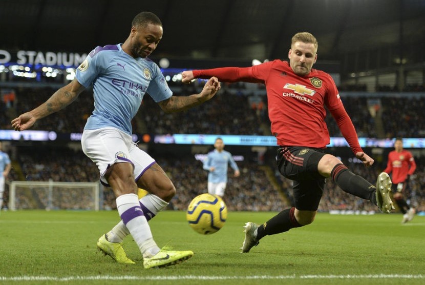 Bek Manchester United (MU) Luke Shaw (kanan) berusaha menahan tendangan winger Manchester City Rahem Sterling. 